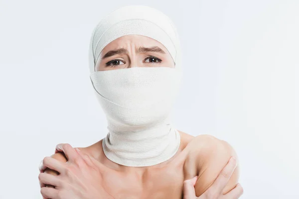 Close up of naked painful woman with white bandages over face and head isolated on white — Stock Photo