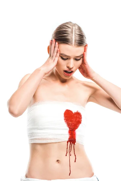 Mulher adulta em ligaduras com coração sangrento isolado em branco — Fotografia de Stock
