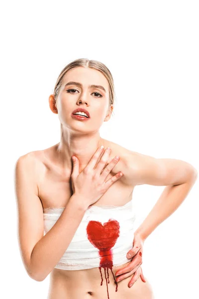 Mujer adulta en vendajes con el corazón ensangrentado aislado en blanco - foto de stock