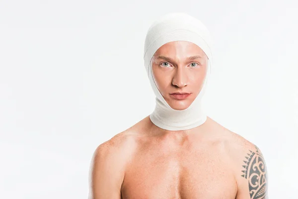 Hombre guapo adulto con vendajes sobre la cabeza después de la cirugía plástica aislado en blanco - foto de stock