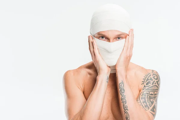 Visage d'homme recouvert de bandages blancs après une chirurgie plastique isolée sur blanc — Photo de stock