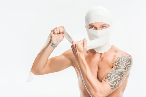 Naked man taking off bandages from head after plastic surgery isolated on white — Stock Photo