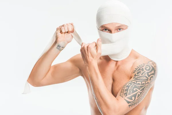 Hombre desnudo quitando vendas de la cabeza después de la cirugía plástica aislado en blanco - foto de stock