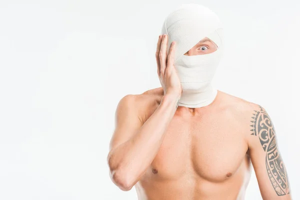 Asustado hombre desnudo con vendajes sobre la cabeza después de la cirugía plástica aislado en blanco - foto de stock