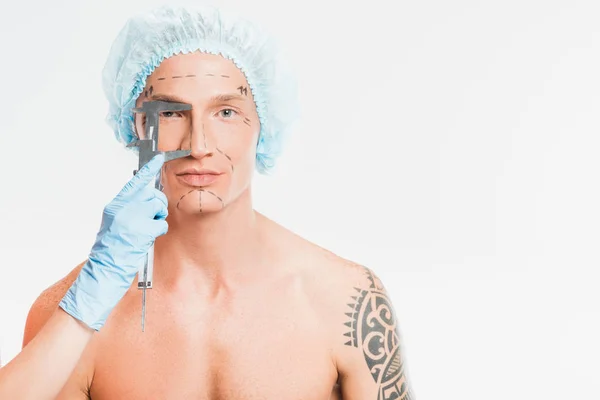 Médico mãos medir cara de homem com marcas desenhadas isolado no branco — Fotografia de Stock
