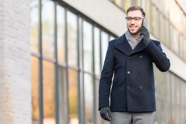 Cheerful man talking on smartphone near building — Stock Photo