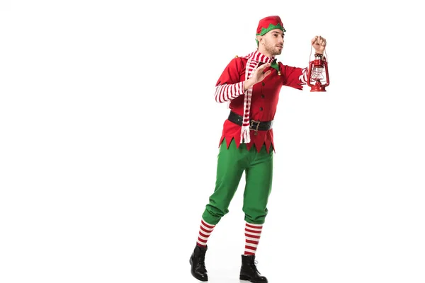 Man in christmas elf costume holding red lantern and looking away isolated on white — Stock Photo