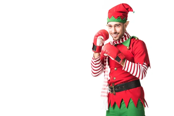 Uomo sorridente in costume elfo di Natale indossa guanti da boxe rossi e guardando la fotocamera isolata su bianco — Foto stock