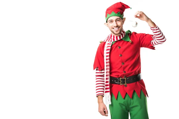 Mann im Weihnachtselfenkostüm hält Christbaumkugel in der Hand, lächelt und blickt vereinzelt in die Kamera — Stockfoto