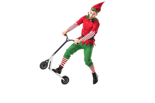 Excited man in christmas elf costume jumping in air on push-cycle isolated on white — Stock Photo