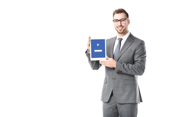 Adulto hombre de negocios sosteniendo tableta digital con aplicación de facebook en la pantalla aislada en blanco - foto de stock