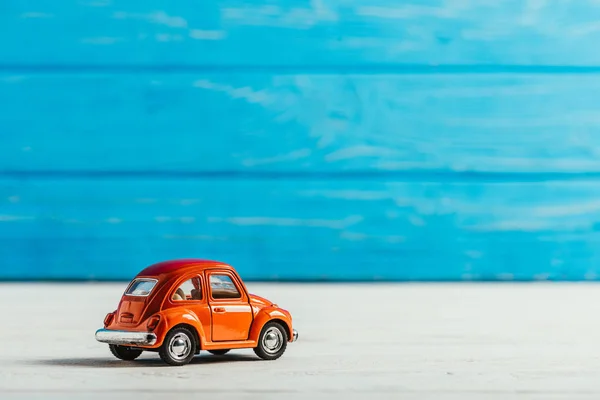 Gros plan de voiture jouet rouge sur fond bleu en bois — Photo de stock