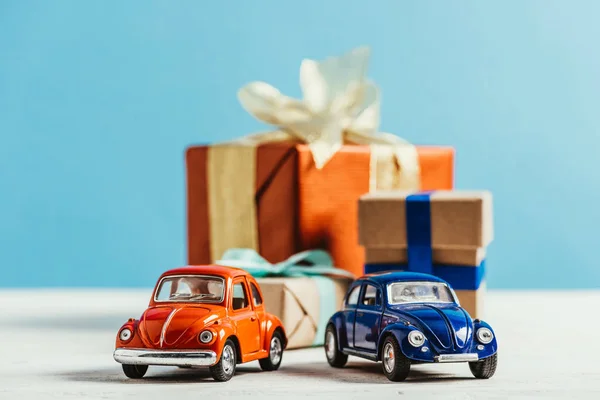 Close-up shot of toy cars with christmas gift boxes on blue background — Stock Photo