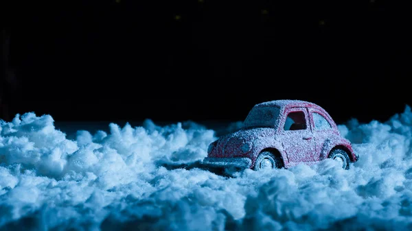 Nahaufnahme von Miniatur-Auto, das in der Nacht im Schnee steht — Stockfoto