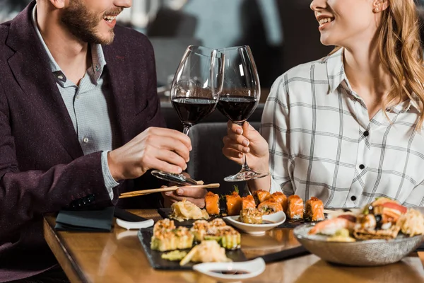 Partial view of couple clinking and having date in restaurant — Stock Photo