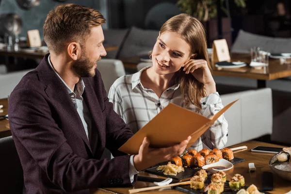 Adorável casal olhando um para o outro enquanto janta no restaurante — Fotografia de Stock