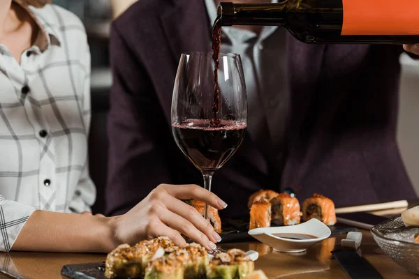 Cropped view of man pouring red wine in glass in restaurant — Stock Photo