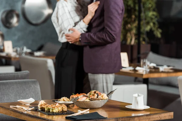 Vista recortada de abrazos pareja de baile en el restaurante - foto de stock