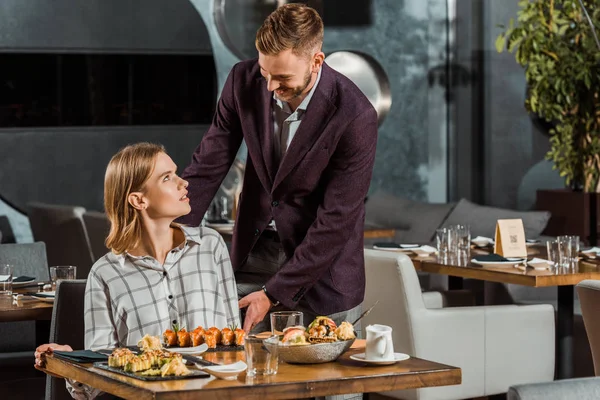 Bonito homem cuidando de sua bela namorada no restaurante — Fotografia de Stock