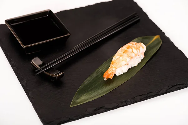 Sushi nigiri con camarones servidos con palillos y salsa de soja sobre pizarra negra — Stock Photo