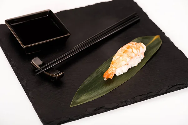 Nigiri sushi with shrimp served with chopsticks and soy sauce on black slate — Stock Photo