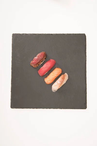 Vista superior del sushi sashimi en pizarra gris - foto de stock