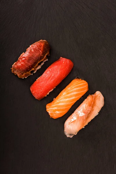 Вид зверху апетитні суші сашімі на чорному шифері — стокове фото