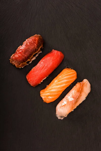 Top view of appetizing sashimi sushi on black slate — Stock Photo