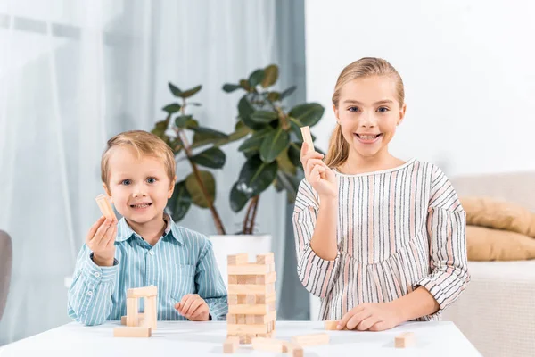 Selective focus of happy adorable children playing blocks wood tower game at home — Stock Photo