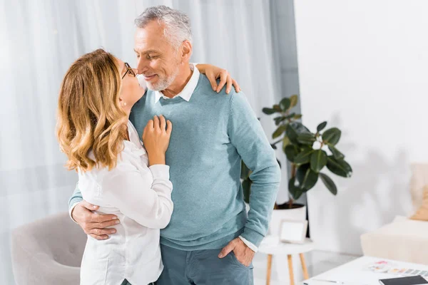 Foyer sélectif de couple s'embrassant et s'embrassant dans le salon à la maison — Photo de stock