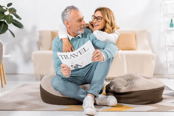 Focus sélectif du couple d'âge moyen lisant le journal de voyage à la maison — Photo de stock