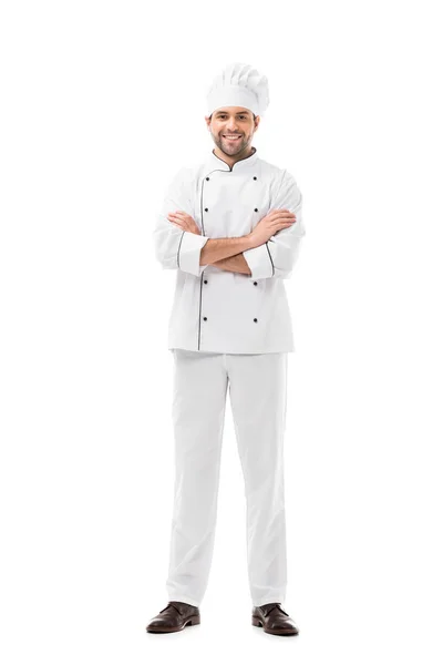 Feliz joven chef con brazos cruzados mirando a la cámara aislada en blanco - foto de stock