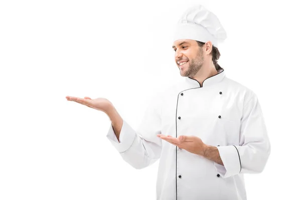 Усміхнений молодий шеф-кухар вказує на порожній простір ізольовано на білому — Stock Photo