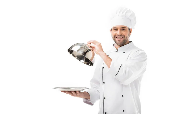 Jovem chef tomando de cúpula servindo de prato isolado em branco — Fotografia de Stock