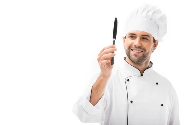 Feliz joven chef sosteniendo cuchillo aislado en blanco - foto de stock