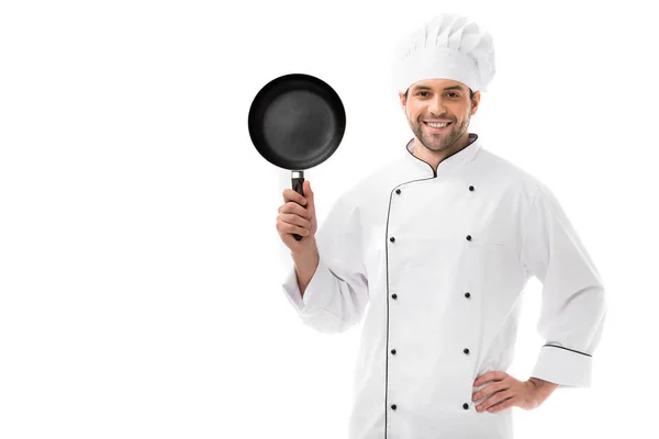 Handsome young chef holding frying pan and looking at camera isolated on white — Stock Photo