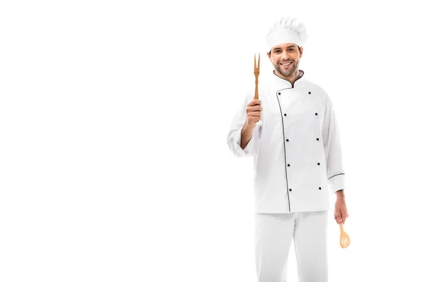 Jovem chef feliz segurando utensílios de cozinha e olhando para a câmera isolada no branco — Fotografia de Stock