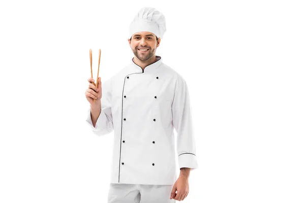 Jovem chef feliz com pinças de madeira olhando para a câmera isolada no branco — Fotografia de Stock