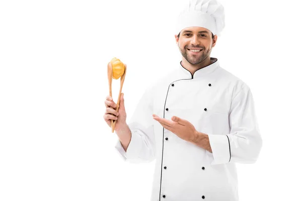 Glücklicher junger Koch hält Pattypan-Kürbis mit einer Zange isoliert auf weiß — Stockfoto