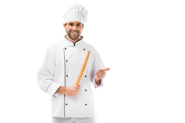 Sonriente joven chef con rodillo mirando a la cámara aislada en blanco - foto de stock