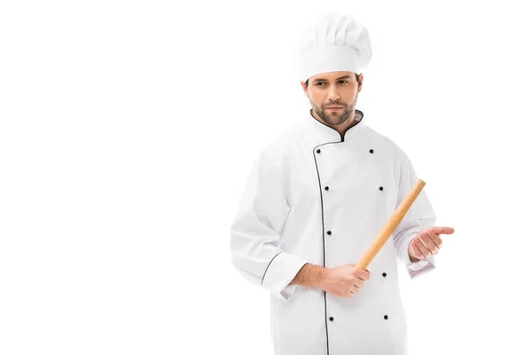 Serious young chef holding rolling pin isolated on white — Stock Photo