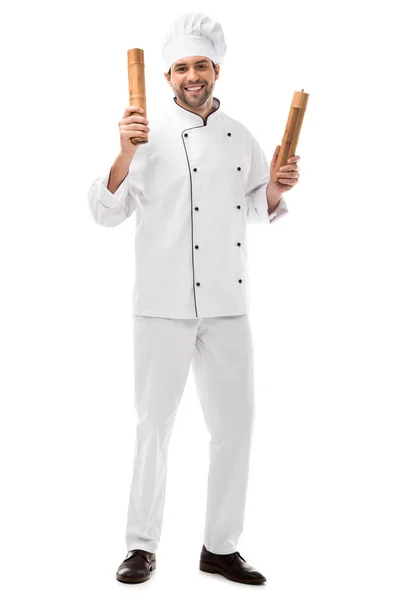 Jovem chef sorrindo segurando moinhos de pimenta de bambu isolado em branco — Fotografia de Stock