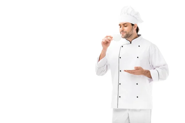 Smiling male cook holding saucer and cup of coffee isolated on white — Stock Photo