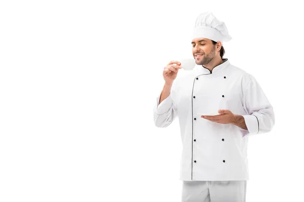 Sorridente chef masculino segurando pires e xícara de café isolado em branco — Fotografia de Stock