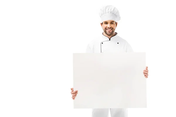 Bonito jovem chef masculino segurando banner em branco e sorrindo para a câmera isolada no branco — Fotografia de Stock