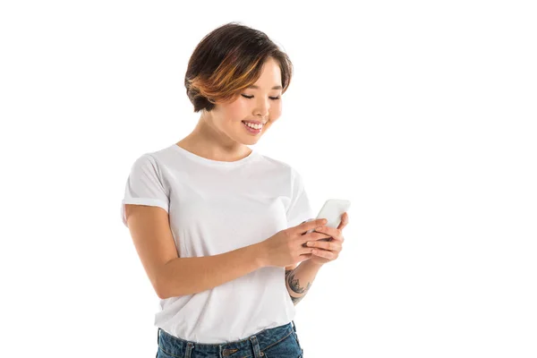 Усміхнена молода жінка використовує смартфон ізольовано на білому — стокове фото