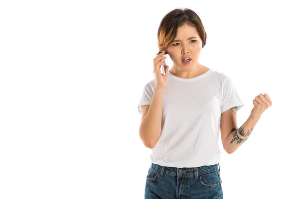 Mujer joven enojada hablando en teléfono inteligente aislado en blanco - foto de stock