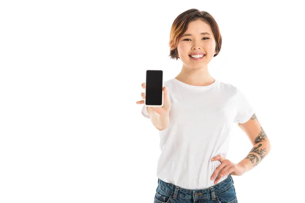 Приваблива молода жінка, що представляє смартфон з порожнім екраном ізольовано на білому — стокове фото