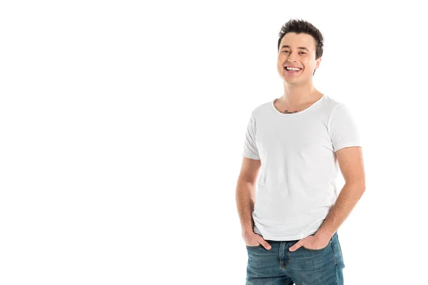 Handsome smiling man with hands in pockets looking at camera isolated on white — Stock Photo