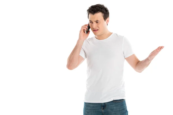 Homem bonito confuso falando no smartphone isolado no branco — Fotografia de Stock